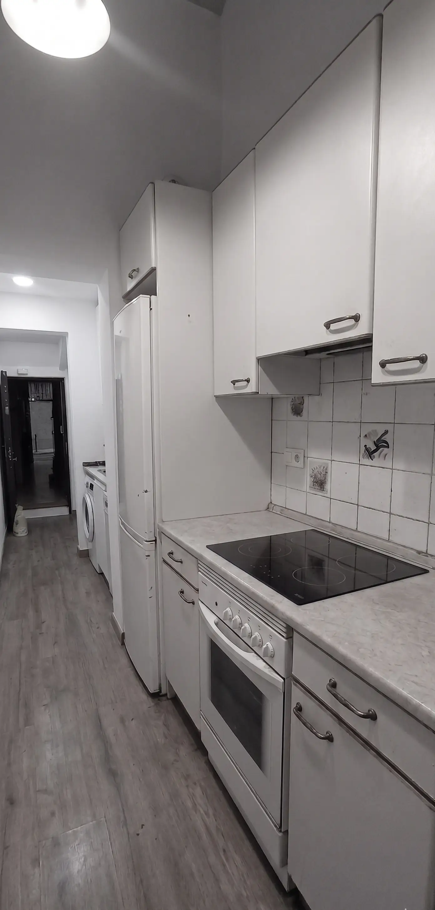 Reforma cocina con mobiliario blanco clásico, encimera de mármol y suelo laminado en Ripollet