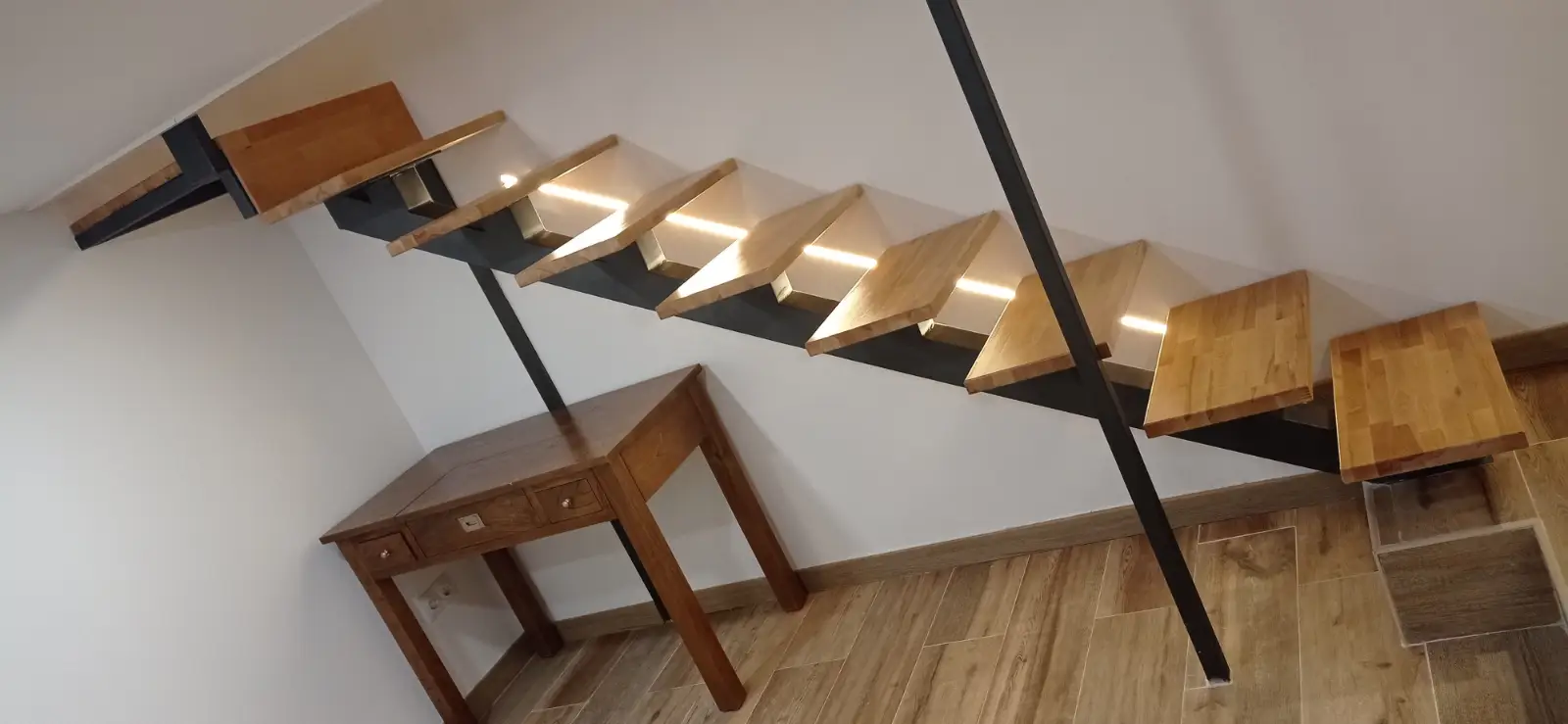 Reforma integral con escalera de peldaños de madera volados e iluminación LED integrada en Ripollet