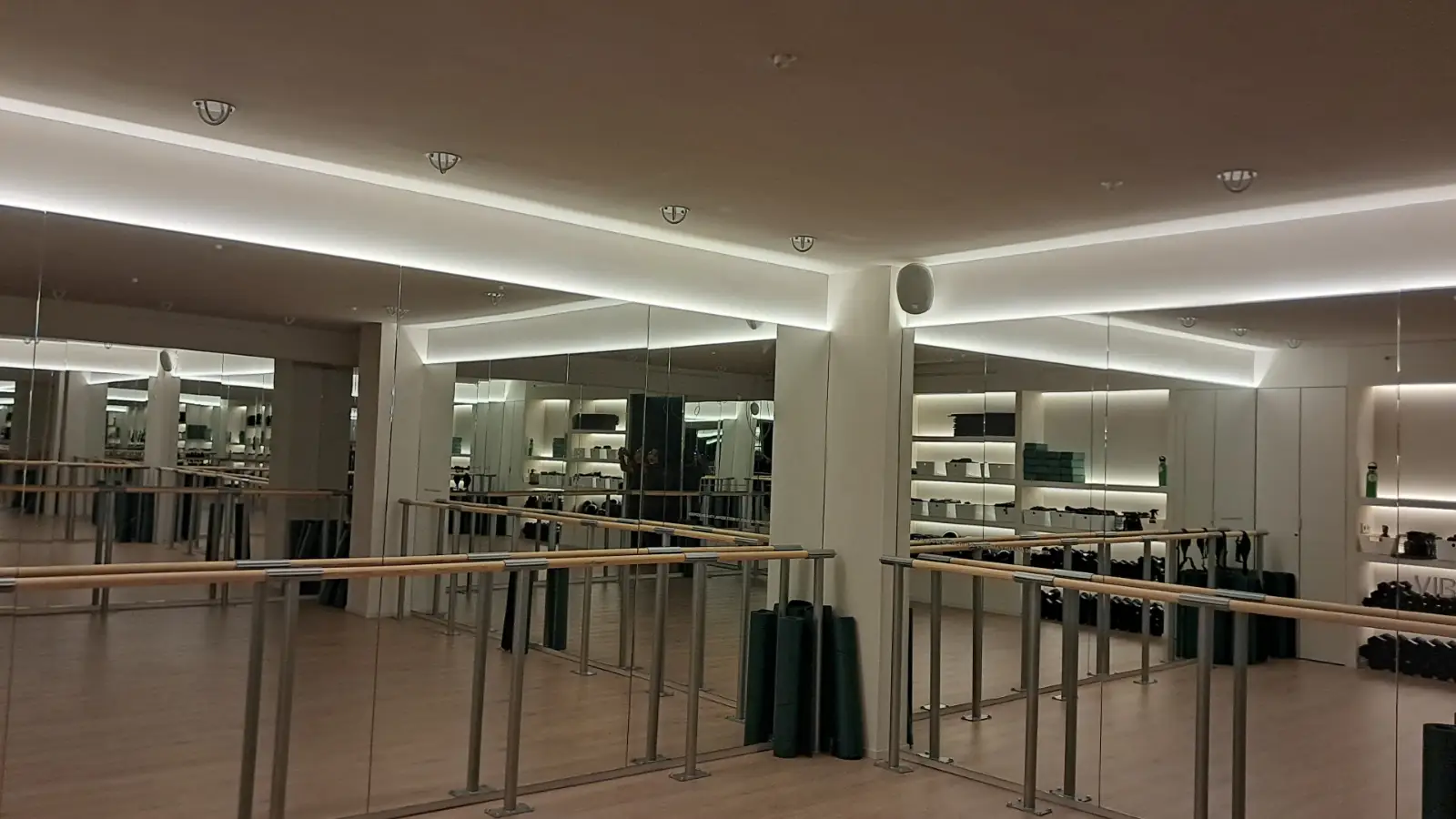 Reforma integral de gimnasio con grandes espejos de pared y barras de madera en Ripollet